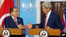 Secretary of State John Kerry, right, shakes hands with Tunisia Foreign Minister Mongi Hamdi, Monday, Aug. 4, 2014, during the US Africa Summit.