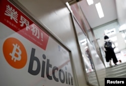 FILE - A logo of Bitcoin is seen on an advertisement of an electronic shop in Tokyo, Japan, Sept. 5, 2017.