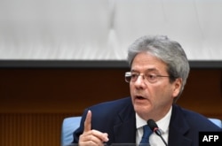 FILE - Italian Prime Minister Paolo Gentiloni gestures as he answers questions from journalists in Rome, Dec. 28, 2017.