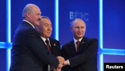 Russian President Vladimir Putin (R), Kazakh President Nursultan Nazarbayev (C) and Belarus President Alexander Lukashenko shake hands during a meeting of the Eurasian Economic Union in Astana, Kazakhstan, May 29, 2014.