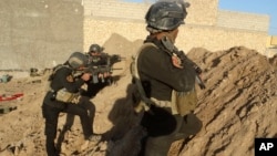 FILE - Iraqi security forces take combat position at the front-line with Islamic State group militants as Iraqi Army and allied Sunni volunteer tribal fighters supported by U.S.-led coalition airstrikes are tightened the siege of Ramadi, Iraq, Nov. 30, 2015. 