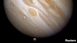 FILE - The planet Jupiter is shown with one of its moons, Ganymede (bottom), in this NASA handout photo, April 9, 2007. 