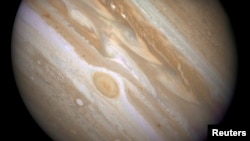 FILE - The planet Jupiter is shown with one of its moons, Ganymede (bottom), in this NASA handout taken April 9, 2007, and obtained by Reuters, March 12, 2015. 