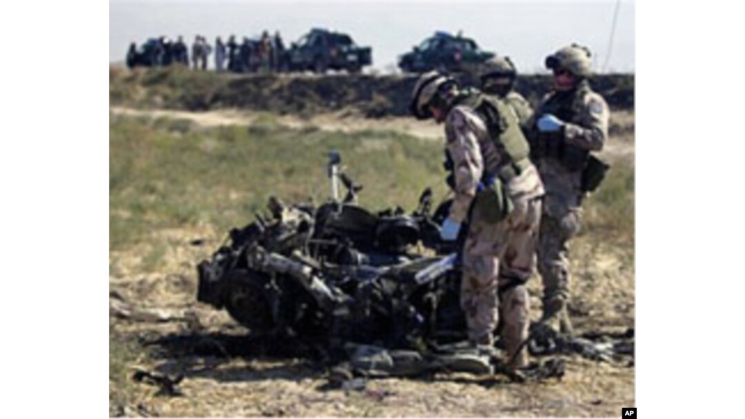 NATO troops from Sweden look at the remains of a suicide bomber's vehicle on the outskirts of Mazar-i-Sharif city in Afghanistan's Balkh province, September 24, 2010