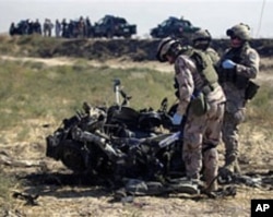 NATO troops from Sweden look at the remains of a suicide bomber's vehicle on the outskirts of Mazar-i-Sharif city in Afghanistan's Balkh province, September 24, 2010