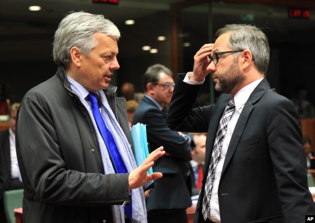 FILE - Belgium's Foreign Minister Didier Reynders, left, talks with Germany's Minister of State Michael Roth during an EU general affairs meeting, at the European Council building in Brussels, May 13, 2014.