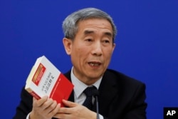 Li Fei, deputy secretary general of the National People's Congress Standing Committee, holds a China's legislation law book while speaking during a press conference at the Great Hall of the People in Beijing, Nov. 7, 2016.