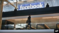 FILE - Facebook logo is displayed in a start-up companies gathering at Paris' Station F, in Paris, Jan. 17, 2017.