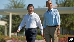 President Barack Obama and Chinese President Xi Jinping, left, walk at the Annenberg Retreat of the Sunnylands estate on June 8, 2013 in Rancho Mirage, Calif.