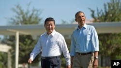 President Barack Obama and Chinese President Xi Jinping, left, walk at the Annenberg Retreat of the Sunnylands estate, June 8, 2013, in Rancho Mirage, Calif.