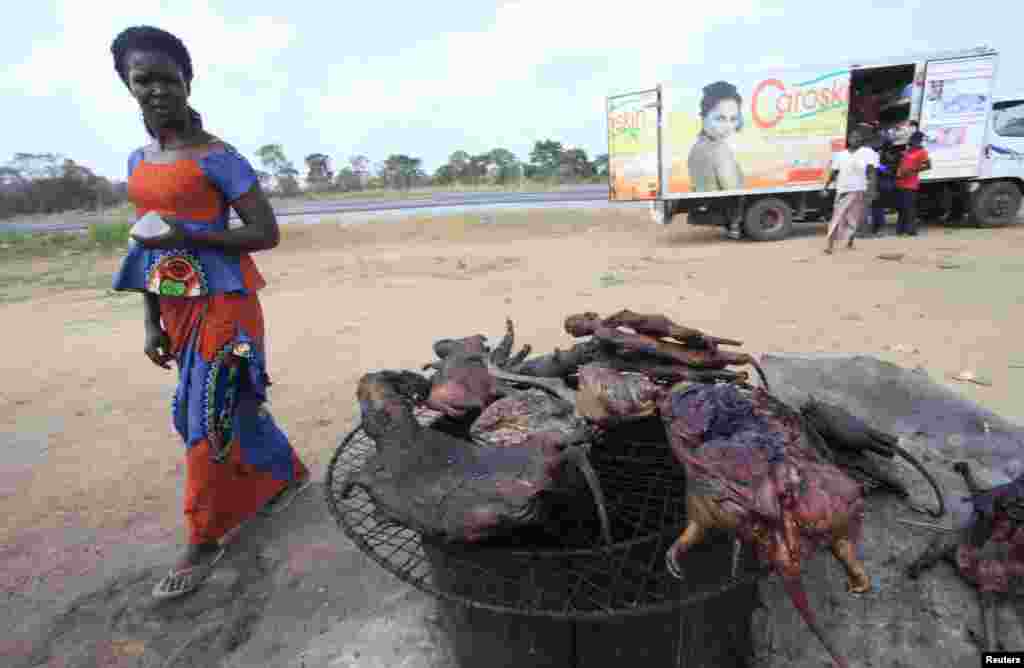 Une femme passe devant la viande de brousse séchée près d&#39;une route de Yamoussoukro, Côte d&rsquo;Ivoire; le 29 mars 2014. REUTERS / Thierry Gouégnon. 