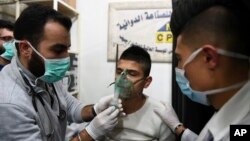 지난 2018년 시리아 알레포에서 화학무기 공격을 당한 것으로 추정되는 주민(가운데)이 산소 마스크를 통해 호흡하고 있다. (자료사진)