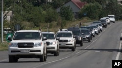 A convoy of International forensic experts, Dutch and Australian policemen and members of the OSCE mission in Ukraine approach Shakhtarsk, Donetsk region, eastern Ukraine, July 28, 2014. 