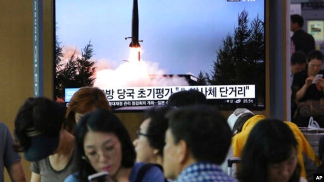 2019年7月25日人们在韩国首尔火车站观看有关朝鲜发射飞行器的电视新闻。