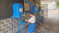 Siswa SD yang mengumpulkan tugas ke sekolah harus menjalani protokol kesehatan sebelum masuk sekolah. (Foto: VOA/Petrus Riski)