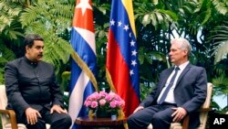 Presiden Kuba Miguel Diaz-Canel, kanan, berbincang dengan Presiden Venezuela Nicolas Maduro dalam sesi foto di Istana Revolusi di Havana, Kuba, Sabtu, 21 April 2018.