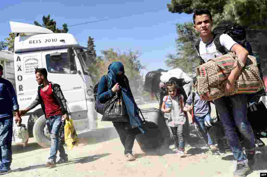 Syrian refugees walk on their way back to the city of Jarabulus at Karkamis crossing gate, in the southern region of Kilis.