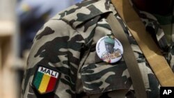A soldier wears a button bearing the image of coup leader Capt. Amadou Haya Sanogo with the words 'President, CNRDRE,' the French acronym of the ruling junta, outside Bamako, Mali, April 1, 2012. 
