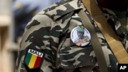 A soldier wears a button bearing the image of coup leader Capt. Amadou Haya Sanogo with the words 'President, CNRDRE,' the French acronym of the ruling junta, outside Bamako, Mali, April 1, 2012. 