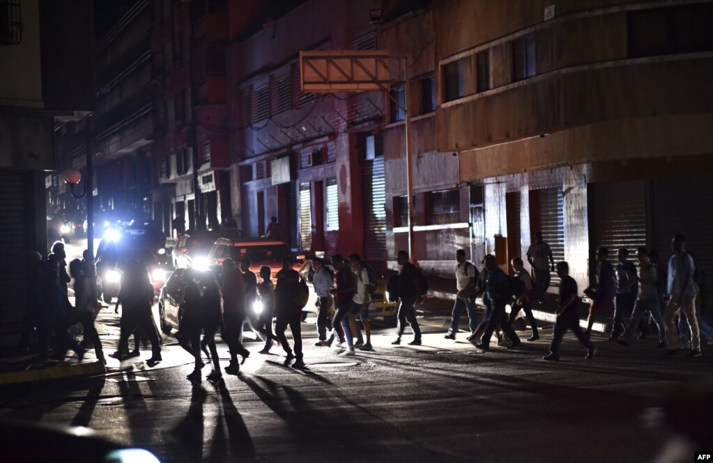 People cross a street in Caracas during a power outage on March 7, 2019 that left much of Venezuela in the dark early Thursday evening in what appeared to be one of the largest blackouts yet.