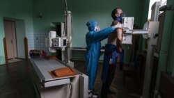 A medic prepares a coronavirus patient for a lung X-ray at a hospital in Stryi, Ukraine, Tuesday, Sept. 29, 2020. (AP Photo/Evgeniy Maloletka)