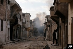 Smoke rises in the east Aleppo neighborhood of Tariq al-Bab after insurgents militants launch a mortar shell on government soldiers in Syria, Dec. 3, 2016.