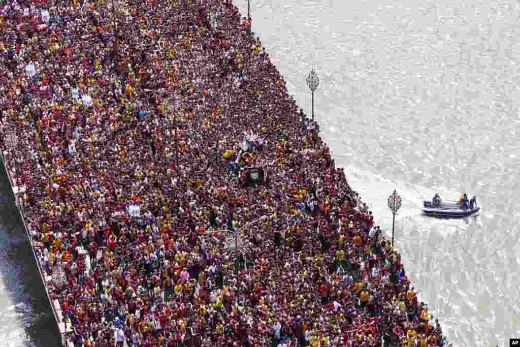 Filipino Roman Catholic devotees cross the bridge in a raucous procession of the Black Nazarene to celebrate its feast day in Manila, Philippines.