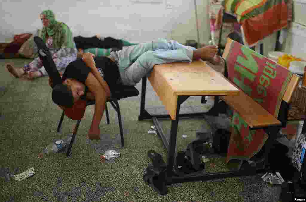 A Palestinian, who fled his family&#39;s house following the Israeli offensive, sleeps as he takes refuge inside a classroom at a United Nations-run school in Jabaliya refugee camp in northern Gaza Strip.