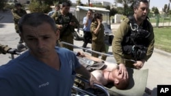 An injured Israeli soldier is wheeled into Soroka hospital in the southern town of Beersheva, Israel, following an exchange of fire with militants along Israel's southern border with Egypt, September 21, 2012.