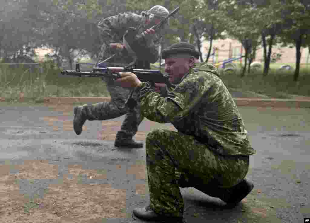 A pro-Russian rebel fires his weapon during clashes with Ukrainian troops on the outskirts of Luhansk, Ukraine, June 2, 2014.