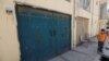 FILE - An Afghan boy looks at the entrance gate of a house, where a German aid worker and an Afghan guard were killed the night before, in Kabul, May 21, 2017. 