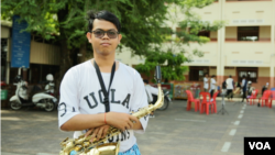 Otdom Praseth, a senior member of the Phnom Penh Marching Band, stands with his saxophone during a rehearsal at Kolab Primary School in Phnom Penh on October 7, 2018. (Rithy Odom/VOA Khmer)