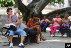 People use the internet at a public Wi-Fi zone in Havana, Cuba, June 4, 2018.