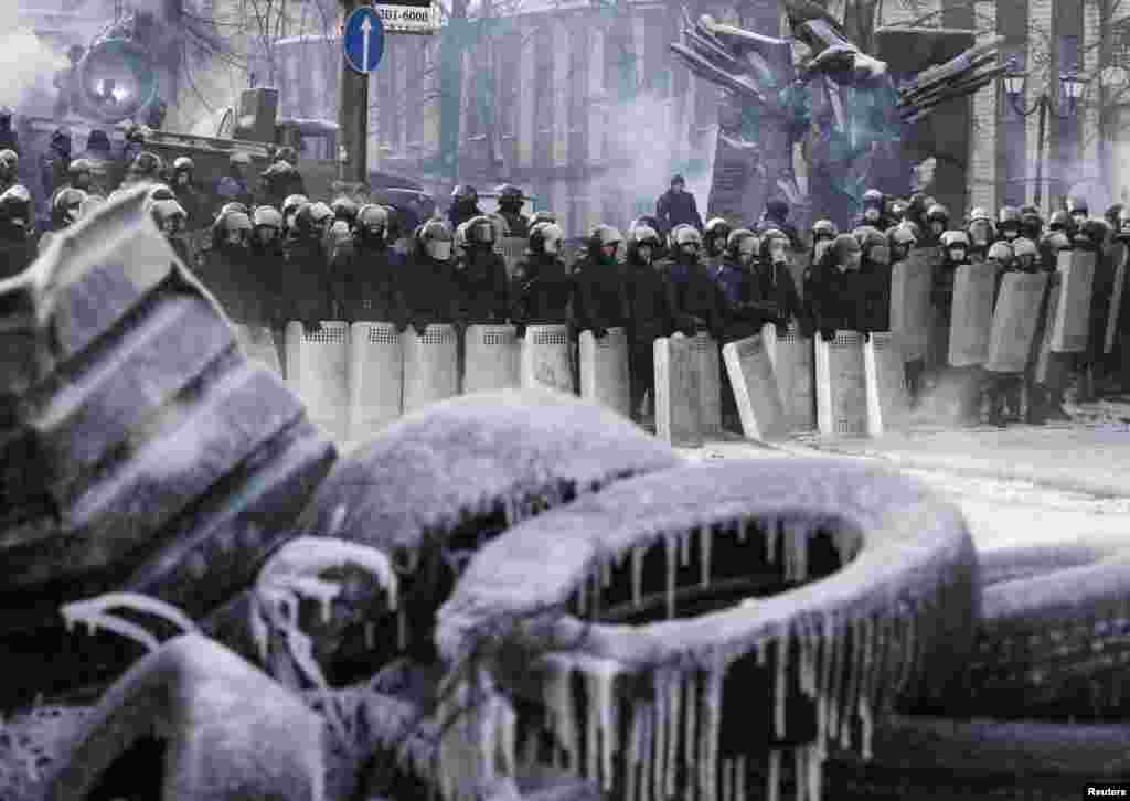 Police stand at the site of clashes with anti-government protesters in Kyiv, Jan. 24, 2014.