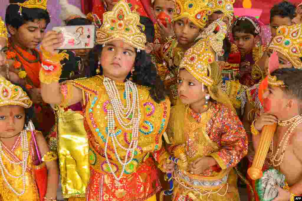 Anak-anak yang berpakaian seperti Dewa Hindu Rama dan Sita mengambil foto selfie pada acara untuk merayakan festival Diwali di kota Ajmer, negara bagian Rajasthan, India barat.
