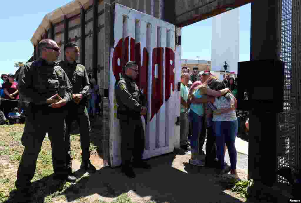 Member of the Reyes family hug as they are reunited for three minutes as U.S. Border patrol agents open a single gate along the Mexico border as part of Children&#39;s Day in Mexico, at Border Field State Park in San Diego, California, April 30, 2017.