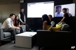 FILE - Canada's Prime Minister Justin Trudeau, left, speaks with AppDirect employees at their office in San Francisco, Feb. 8, 2018. Canadian Prime Minister Justin Trudeau came to San Francisco to pitch Canada as a destination for American tech firms amid increasing unease over U.S. immigration policy.