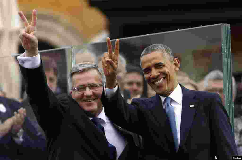 U.S. President Barack Obama and Polish President Bronislaw Komorowski show the peace sign at a Freedom Day event at Royal Square in Warsaw, June 4, 2014.