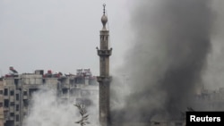 Smoke rises from a mosque and another building during heavy fighting between the Free Syrian Army and President Bashar al-Assad's forces, in the Jobar area of Damascus Feb. 6, 2013. 