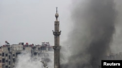 Smoke rises from a mosque and another building during heavy fighting in the Jobar area of Damascus Feb. 6, 2013. (Reuters)