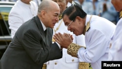 Cambodia's King Norodom Sihamoni is greeted by Prime Minister Hun Sen during the celebration marking the 64th anniversary of the country's independence from France, in Phnom Penh, Cambodia, Nov. 9, 2017.