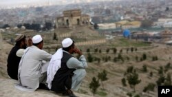 Men sit on the Nadir Khan hilltop overlooking Kabul, Afghanistan, March 27, 2017. American and Afghan officials are increasingly wary of the deepening ties between Russia and the Taliban that is fighting to topple the government in Kabul. 
