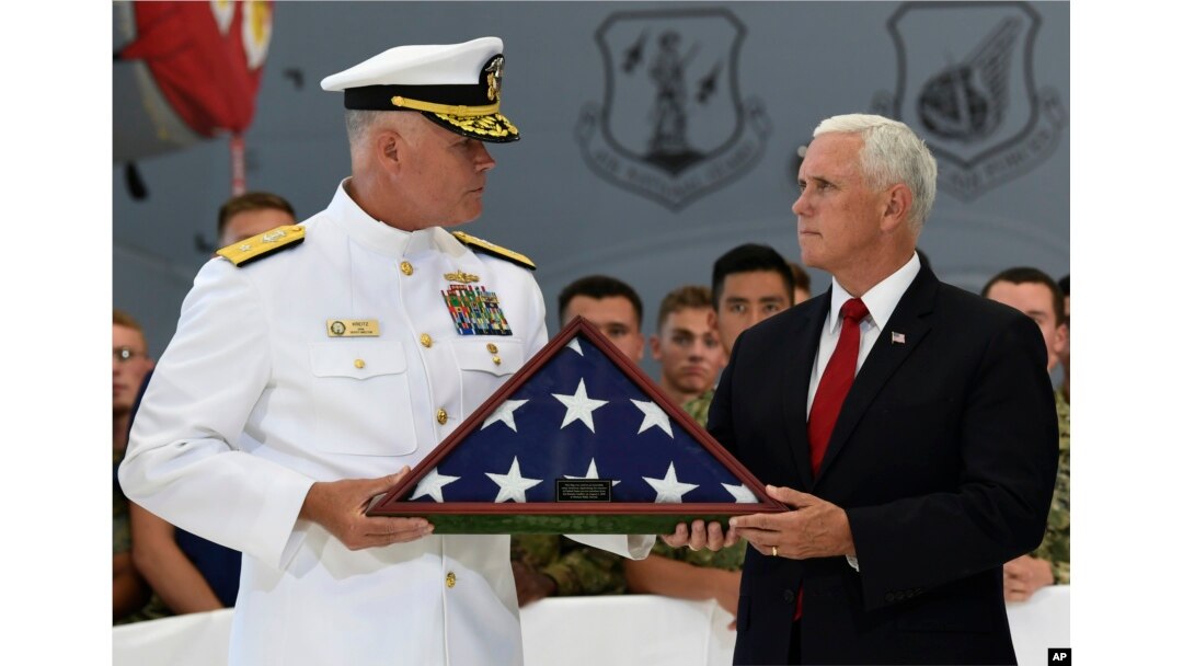 Vice President Mike Pence (R) receives a flag from Navy Rear Adm. Jon Kreitz, deputy director of the POW/MIA Accounting Agency during a visit to Joint Base Pearl Harbor-Hickam in Hawaii, Aug. 1, 2018.