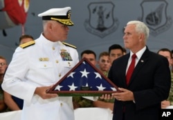 Vice President Mike Pence (R) receives a flag from Navy Rear Adm. Jon Kreitz, deputy director of the POW/MIA Accounting Agency during a visit to Joint Base Pearl Harbor-Hickam in Hawaii, Aug. 1, 2018.