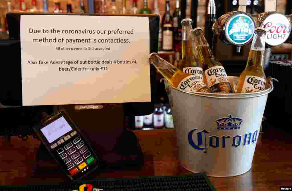 A sign asking customers to only use contactless payment methods is seen in a pub in Liverpool, Britain, March 17, 2020.