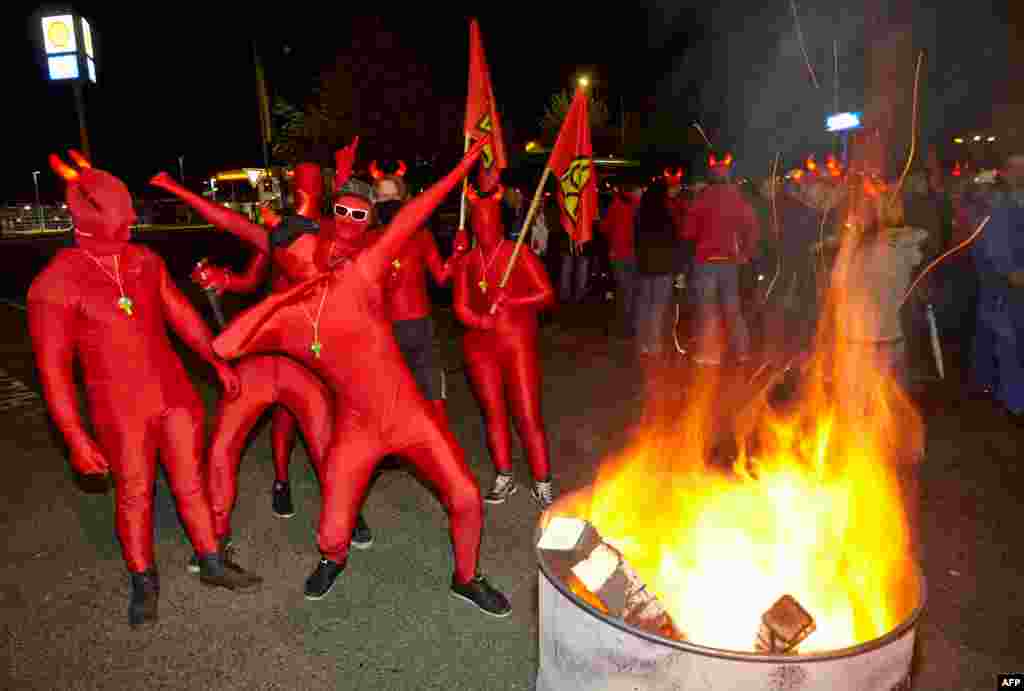Workers of the Rasselstein tinplate maker wear red morphsuits and hold flags of the German union IG Metall as they demonstrate during a warning strike in Andernach, western Germany. 