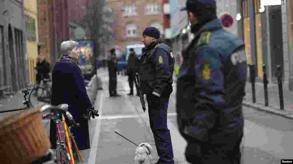 Une femme parle à des officiers de police en face de la synagogue de Krystalgade à Copenhague, le 15 février 2015.