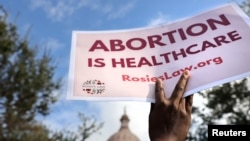 Defensores del aborto protestan con un cartel de "El aborto es atención de la salud" ante el Capitolio estatal de Texas en Austin el 2 de octubre de 2021.