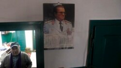 In this photo taken on Thursday, Jan. 23, 2020, Uros Trainovic walks inside his house decorated with picture of former Yugoslav communist president Josip Broz Tito, in the village of Blagojev Kamen, Serbia. (AP Photo/Darko Vojinovic)