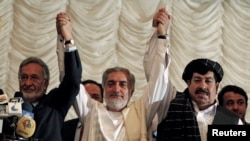 Afghan presidential candidates Abdullah Abdullah (C) with Zalmai Rassoul (L) and Gul Agha Shirzai (R) attend a joint news conference in Kabul, May 11, 2014. 